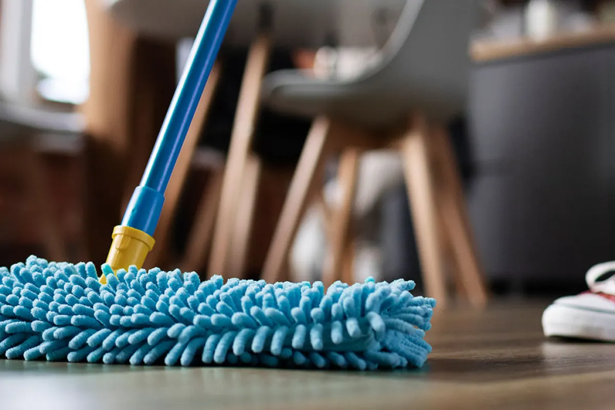 Lavage d'un parquet avec un balai microfibre dans un salon