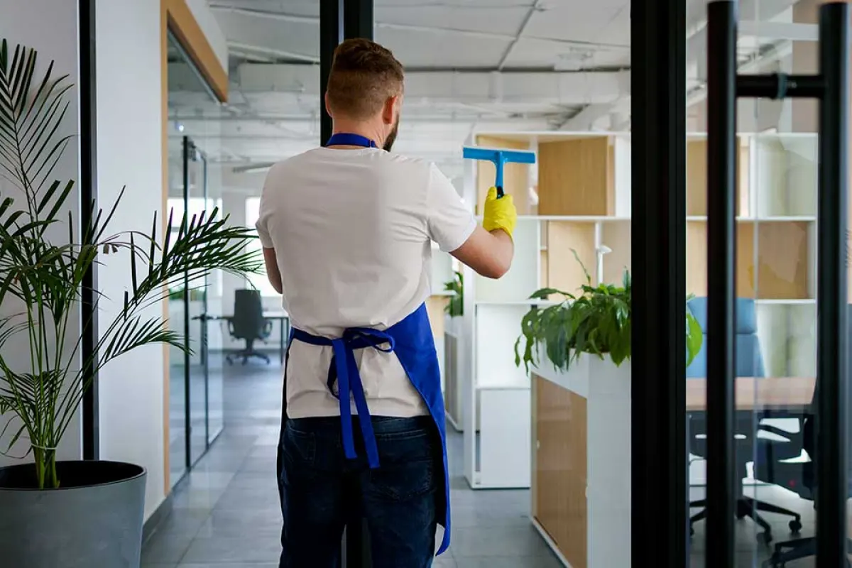 Nettoyage d'une vitre de bureau à la raclette